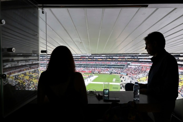 Roberto Ruano, el secretario de una asociación de propietarios de palcos del Estadio Azteca de la Ciudad de México y su pareja Eve de la Torre, presencian un partido de la Kings League en su palco preferencial, el sábado 4 de mayo de 2024. (AP Foto/Ginnette Riquelme)