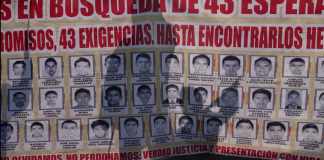 ARCHIVO - Familiares y amigos de los 43 estudiantes de Ayotzinapa desaparecidos marchan con un cartel con las fotos y el nombre de los jóvenes en el noveno aniversario de su desaparición, en Ciudad de México, el 26 de septiembre de 2023. Una corte federal mexicana decidió el jueves 9 de mayo de 2024 que ocho de los militares acusados en el caso Ayotzinapa sigan el proceso en libertad. (AP Foto/Marco Ugarte, Archivo)