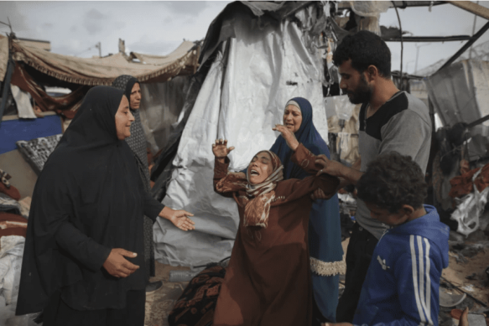 Palestinos desplazados inspeccionan sus tiendas destruidas por el bombardeo de Israel, adjuntas a una instalación de UNRWA al oeste de la ciudad de Rafah, Franja de Gaza, el 28 de mayo de 2024. 