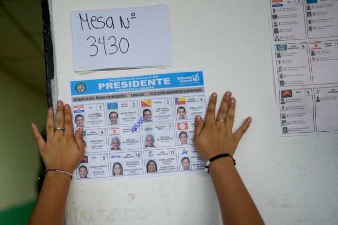 Un trabajador electoral coloca en una pizarra una papeleta de muestra en un centro de votación en las elecciones generales en Ciudad de Panamá, el domingo 5 de mayo de 2024.