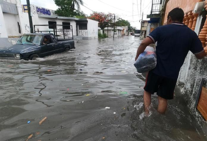 Fotografía de un vehículo que circula por una calle inundada debido a las fuertes lluvias de este martes, en el balneario de Cancún, estado de Quintana Roo (México). EFE/Alonso Cupul