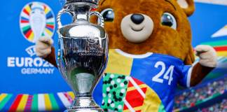 Albaert, la mascota de la Eurocopa 2024, posa junto al trofeo del torneo, en una foto de archivo. EFE/EPA/HANNIBAL HANSCHKE