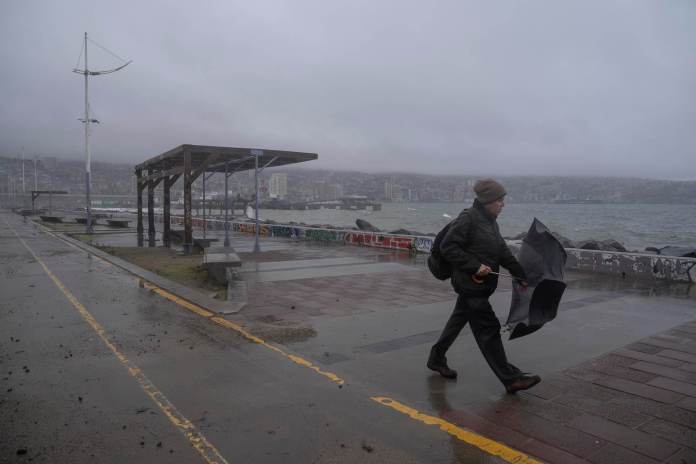 Un hombre camina frente a la costa durante un clima lluvioso. EFE/ Adriana Thomasa