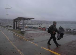 Un hombre camina frente a la costa durante un clima lluvioso. EFE/ Adriana Thomasa