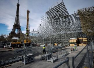 Trabajadores construyen gradas para los venideros Juegos Olímpicos en el Campo de Marte, justo al lado de la Torre Eiffel, en París, el 1 de abril de 2024. (AP Foto/Thomas Padilla)