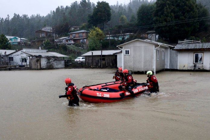 Trabajadores de rescate empujan un bote inflable en el río Pichilo. (Foto AP/Amilix Fornerod)