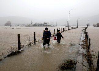 La gente camina por una carretera inundada en río Pichilo, Arauco, Chile. (Foto AP/Amilix Fornerod)