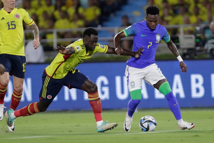 El brasieño Vinicius Junior y el colombiano Davinson Sánchez disputan el balón en el partido por las eliminatorias del Mundial, el jueves 16 de noviemnbre de 2023, en Barranquilla, Colombia. (AP Foto/Iván Valencia, File)