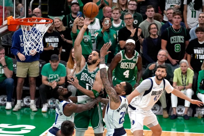 El delantero de los Boston Celtics, Jayson Tatum (0), dispara a la canasta mientras el delantero de los Dallas Mavericks, Tim Hardaway Jr., izquierda, el delantero PJ Washington (25) y el delantero Maxi Kleber (42) defienden durante la segunda mitad del Juego 5 de las finales de baloncesto de la NBA el lunes. , 17 de junio de 2024, en Boston. (Foto AP/Charles Krupa)