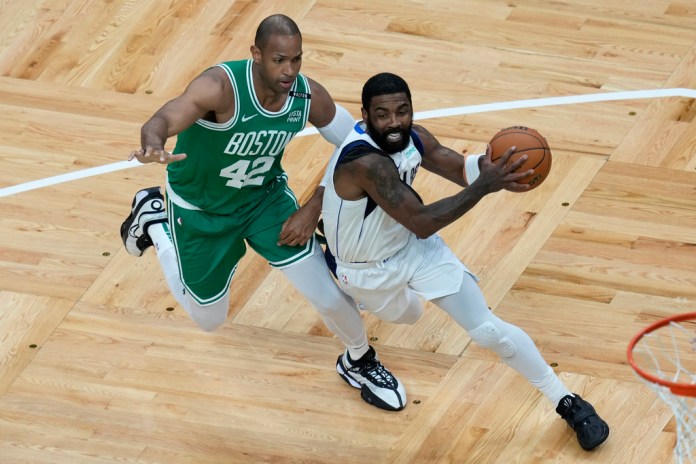 Kyrie Irving (derecha) de los Mavericks de Dallas se desmarca de Al Horford de los Celtics de Boston en el quinto juego de las Finales de la NBA, el lunes 17 de junio de 2024, en Boston. (AP Foto/Michael Dwyer)