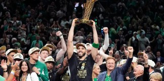 El delantero de los Boston Celtics, Jayson Tatum, sostiene, en el centro, el Trofeo del Campeonato Larry O'Brien mientras celebra con el equipo después de que ganaron el campeonato de baloncesto de la NBA con una victoria en el Juego 5 sobre los Dallas Mavericks, el lunes 17 de junio de 2024, en Boston. (Foto AP/Charles Krupa)