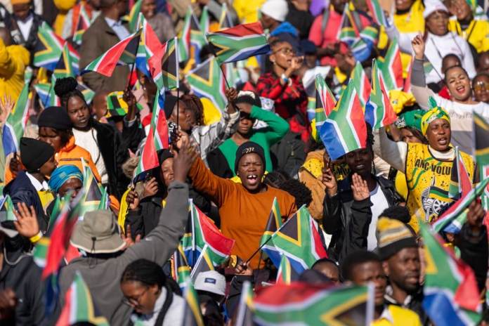 Sudafricanos se congregan antes de la toma de posesión de Cyril Ramaphosa como presidente de Sudáfrica, en Tshwane, Sudáfrica, el 19 de junio de 2024. (AP Foto/Jerome Delay)