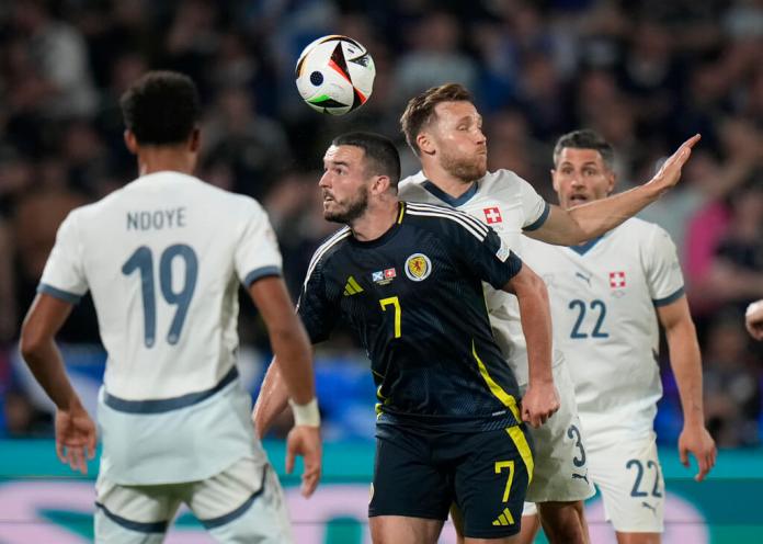 El escocés John McGinn y el suizo Silvan Widmer saltan por el balón durante el encuentro del Grupo A de la Eurocopa. (AP Foto/Alessandra Tarantino)
