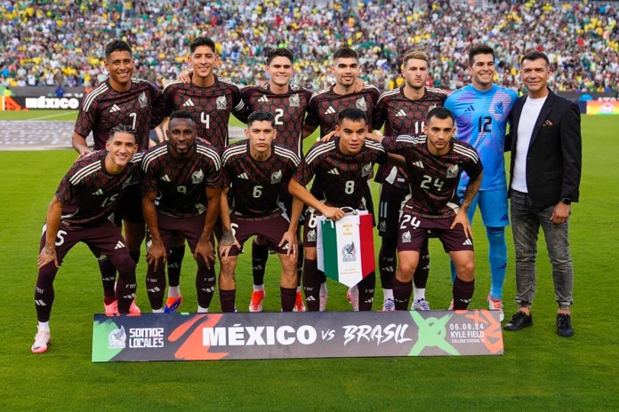 El equipo titular de México posa para una fotografía junto al exjugador Jared Borgetti, derecha, previo a un partido amistoso ante Brasil, el 8 de junio de 2024 en el Kyle Field en College Station, Texas. (AP Foto/Julio Cortez)