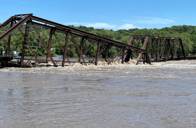 Un puente ferroviario que vincula a North Sioux City, Dakota del Sur, con Sioux City, Iowa, yace parcialmente sobre el río Big Sioux el lunes 24 de junio de 2024 debido a inundaciones. (AP Foto/Margery A. Beck)