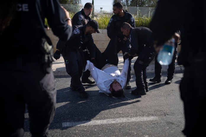 Agentes de policía israelíes se llevan a un hombre judío ultraortodoxo de la calle durante una protesta contra el reclutamiento militar en Jerusalén, el 2 de junio de 2024. (AP Foto/Leo Correa, Archivo)