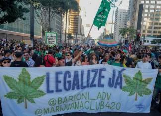 Manifestantes sostienen una manta que dice en portugués, "Legalícenla ya", en una marcha para exigir la legalización de la marihuana, en Sao Paulo, el domingo 16 de junio de 2024. (AP Foto/Andre Penner)