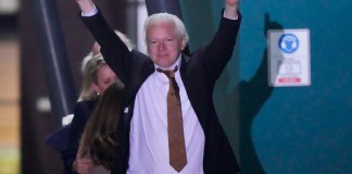 Julian Assange, fundador de WikiLeaks, hace un gesto con los brazos y los pulgares en alto tras aterrizar en la base de las Fuerzas Armadas Australianas. (AP Foto/Rick Rycroft)