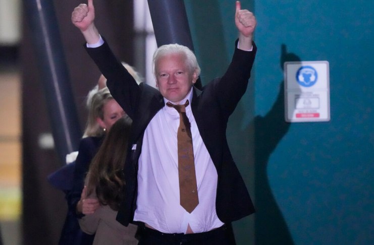 Julian Assange, fundador de WikiLeaks, hace un gesto con los brazos y los pulgares en alto tras aterrizar en la base de las Fuerzas Armadas Australianas. (AP Foto/Rick Rycroft)