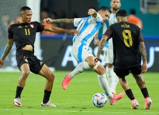 El argentino Leandro Paredes (centro) pugna por el balón con los peruanos Bryan Reyna (11) y Sergio Peña (8) contra Perú por el Grupo A de la Copa América, el sábado 29 de junio de 2024, en Miami Gardens, Florida. (AP Foto/Rebecca Blackwell)