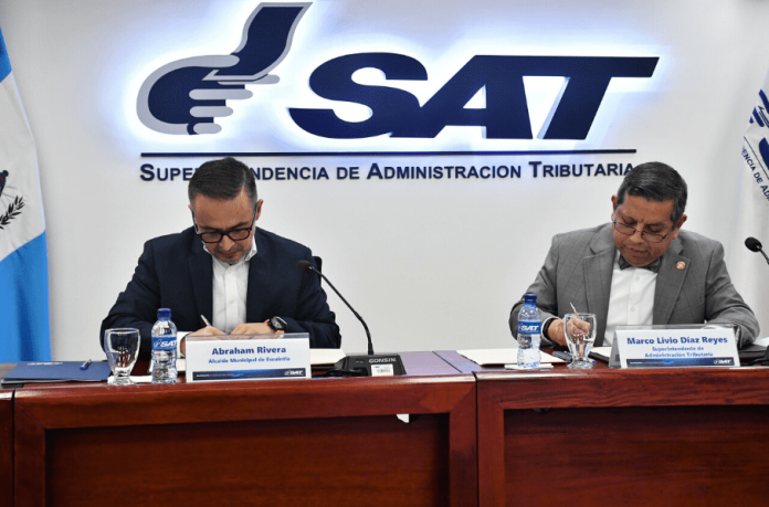 Abraham Rivera, Alcalde de la Municipalidad de Escuintla y Marco Livio Díaz, Superintendente de la SAT firman convenio de cooperación. Foto La Hora / SAT