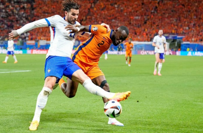 El holandés Lutsharel Geertruida pelea por el balón con el francés Theo Hernandez en el encuentro del Grupo D de la Eurocopa. (AP Foto/Ariel Schalit)