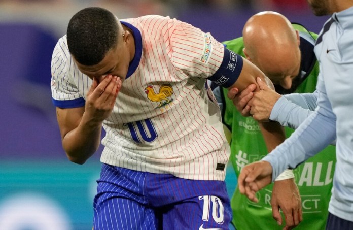 Kylian Mbappé se tapa la nariz después de sufrir una lesión durante un partido del Grupo D entre Austria y Francia. (Foto AP/Martin Meissner)