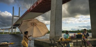 Los vendedores instalan puestos de comida debajo de un puente que forma parte de un proyecto de carretera federal que se extiende sobre el río Nanay, en Iquitos, Perú, el 27 de mayo de 2024. (Foto AP/Rodrigo Abd)
