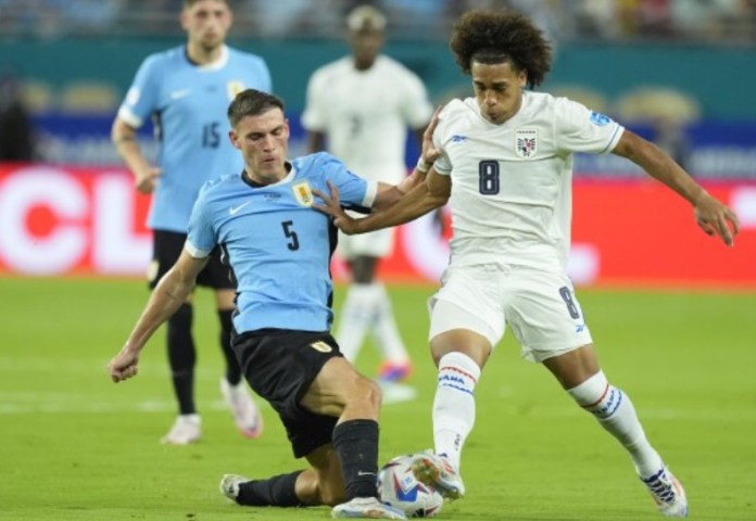 Adalberto Carrasquilla, de Panamá, derecha, y Manuel Ugarte, de Uruguay, luchan por el balón durante un partido de fútbol del Grupo C de la Copa América en Miami Gardens, Florida, el domingo 23 de junio de 2024. (Foto AP/Rebecca Blackwell)