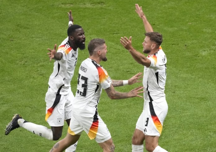 l alemán Niclas Fuellkrug, a la derecha, celebra con el alemán Antonio Ruediger, a la izquierda, y el alemán Robert Andrich después de anotar el segundo gol de su equipo durante un partido del Grupo A entre Suiza y Alemania en el torneo de fútbol Euro 2024 en Frankfurt, Alemania, el domingo 23 de junio de 2024. (Foto AP/Michael