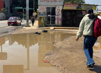 Personas caminan entre agua estancada en una calle, este viernes en Oaxaca (México). EFE/Jesús Méndez