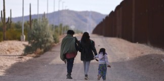 Fotografía de archivo de una familia que camina a lo largo del muro fronterizo estadounidense en busca de la Patrulla Fronteriza para ser procesados en Lukeville, Arizona, EE.UU.. EFE/EPA/Allison Cena