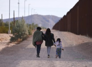 Fotografía de archivo de una familia que camina a lo largo del muro fronterizo estadounidense en busca de la Patrulla Fronteriza para ser procesados en Lukeville, Arizona, EE.UU.. EFE/EPA/Allison Cena