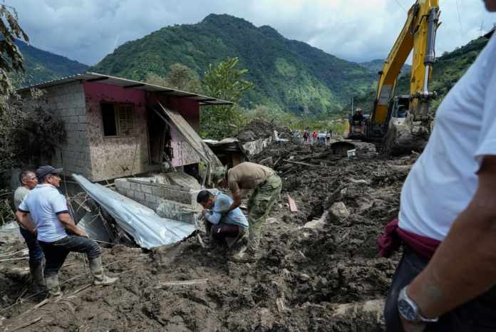 Un residente, arrodillado, reacciona después de que deslizamientos de tierra dañaron su casa en El Placer, Ecuador, el lunes 17 de junio de 2024. (Foto AP/Dolores Ochoa)