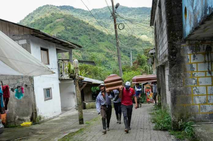 Residentes cargan ataúdes de quienes murieron en deslizamientos de tierra en El Placer, Ecuador, el lunes 17 de junio de 2024. (Foto AP/Dolores Ochoa)