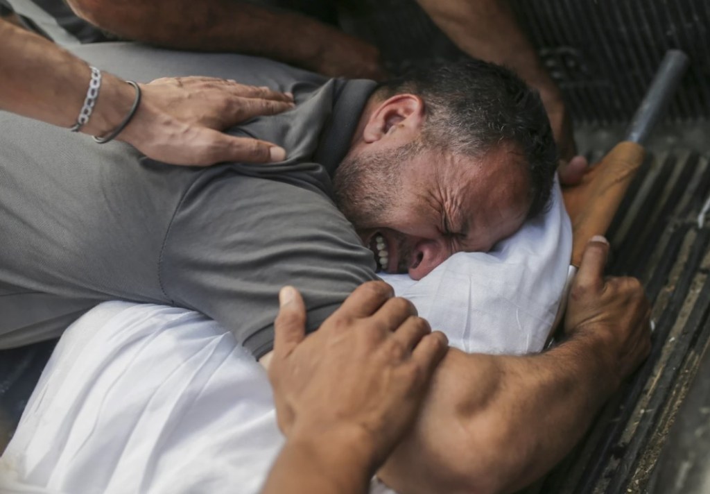 Palestinos lloran por los cuerpos de familiares muertos en un ataque aéreo israelí, en una morgue del Hospital de los Mártires de Al-Aqsa en Deir al Balah, Franja de Gaza, el lunes 10 de junio de 2024.