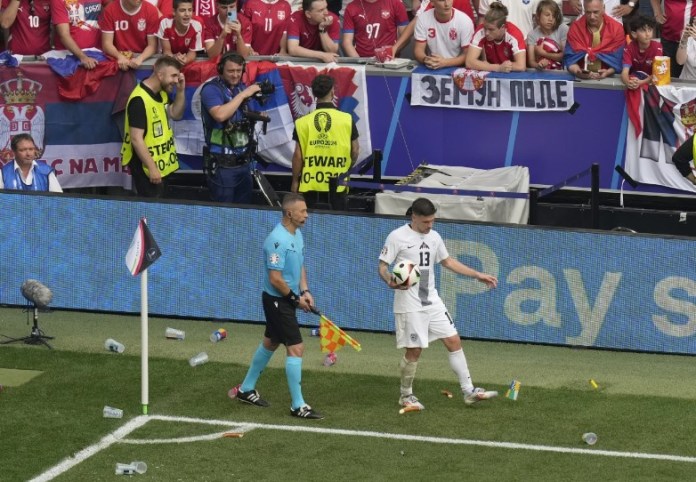 | El esloveno Erik Janza patea comida y vasos de plástico arrojados desde las gradas durante un partido del Grupo C entre Eslovenia y Serbia en el torneo de fútbol Euro 2024 en Múnich, Alemania, el jueves 20 de junio de 2024. (Foto AP/Ariel Schalit)