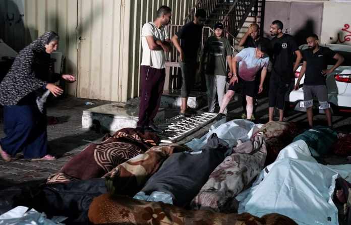 En esta fotografía tomada frente a la morgue del hospital Mártires de Al Aqsa en Deir al-Balah, en la Franja de Gaza, el jueves 6 de junio de 2024, varios palestinos lloran por sus familiares muertos por un bombardeo israelí contra una escuela de la ONU en el campamento de refugiados de Nusseirat. (AP Foto/Abdel Kareem Hana)