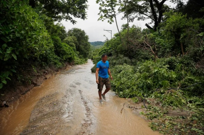 Un hombre camina por un sendero inundado debido a fuertes lluvias, el pasado 21 de junio del 2024, en Soyapango (El Salvador). EFE/ Rodrigo Sura