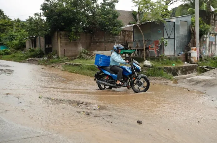 Un hombre en una motocicleta cruza una calle inundada debido a fuertes lluvias, el pasado 21 de junio del 2024, en Soyapango (El Salvador). EFE/ Rodrigo Sura