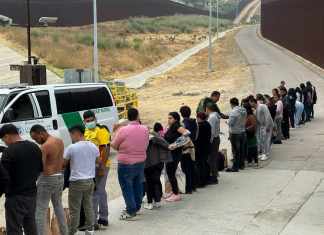 Migrantes que buscan asilo se forman mientras esperan ser procesados luego de cruzar la frontera desde México, el miércoles 5 de junio de 2024, en San Diego, California. (AP Foto/Eugene Garcia)