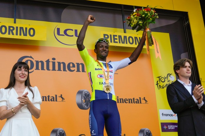 El ganador de la etapa, el eritreo Biniam Girmay, celebra en el podio después de la tercera etapa de la carrera ciclista del Tour de Francia sobre 230,8 kilómetros (143,4 millas) con salida en Piacenza y llegada en Turín, Italia, el lunes 1 de julio de 2024. (AP Foto/Jerome Delay)