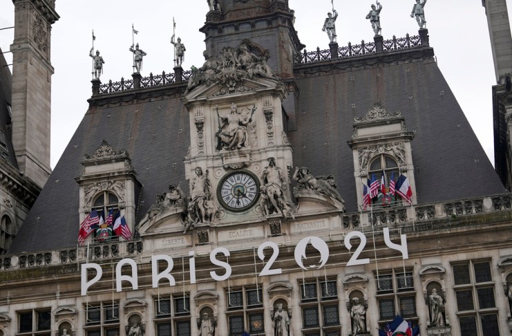 El logo de los Juegos Olímpicos de París 2024 cuelga de la fachada del Ayuntamiento de París, el miércoles 3 de julio de 2024, en París. Tan solo tres semanas previo a los Juegos Olímpicos, la emocionante infraestructura, la expectativa en la ciudad anfitriona se ha visto mezclada con la ansiedad acerca del fúturo político de Francia. (AP Foto/Thibault Camus)