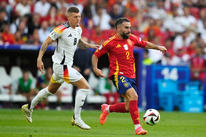 El español Dani Carvajal (2) regatea al alemán Toni Kroos (8) durante un partido de cuartos de final entre Alemania y España en el torneo de fútbol Euro 2024 en Stuttgart, Alemania, el viernes 5 de julio de 2024. (Foto AP/Antonio Calanni)