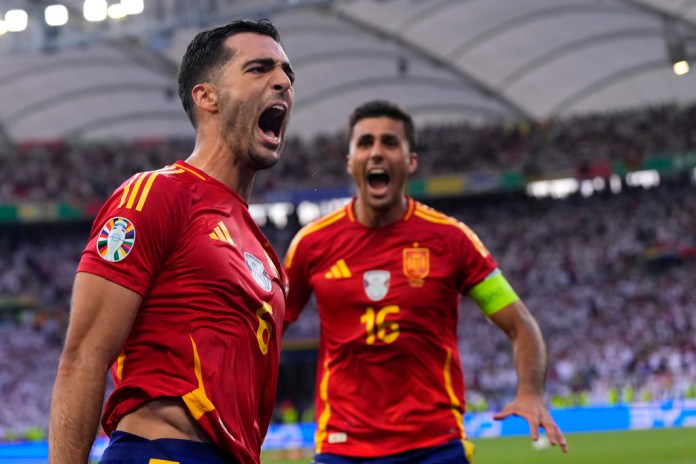 El español Mikel Merino celebra con su compañero Rodri tras anotar el gol de la victoria en el duelo de cuartos de final de la Eurocopa ante Alemania en Stuttgart el viernes 5 de julio del 2024. (AP Foto/Manu Fernandez)