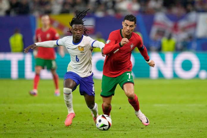 Eduardo Camavinga de Francia disputa el balón con Cristiano Ronaldo de Portugal, a la derecha, durante un partido de cuartos de final entre Portugal y Francia en el torneo de fútbol Euro 2024 en Hamburgo, Alemania, el viernes 5 de julio de 2024. (Foto AP/Martin Meissner)