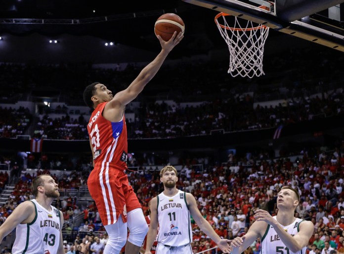 Tremont Waters, de Puerto Rico tira hacia el aro mientras Arnas Butkevicius (derecha), Domantas Sabonis (segundo desde la derecha), y Lukas Lekavicius, observan en el juego final del Torneo Clasificatorio Olímpico de FIBA en San Juan, Puerto Rico, el domingo 7 de julio de 2024. (AP Foto/Alejandro Granadillo)