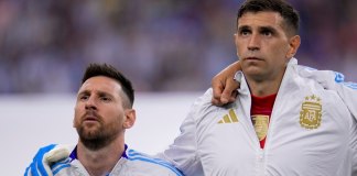 El delantero argentino Lionel Messi (izquierda) y el arquero Emiliano Martínez durante la ceremonia de himnos previo al partido contra Ecuador por los cuartos de final de la Copa América, el jueves 4 de julio de 2024, en Houston. (AP Foto/Julio Cortez)