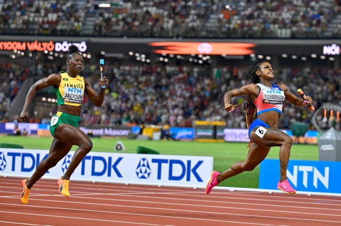 ARCHIVO - La estadounidense Sha'Carri Richardson festeja tras dar el oro a su equipo, al superar a Shericka Jackson en el relevo 4x100 durante el Mundial de atletismo en Budapest, el sábado 26 de agosto de 2023 (AP Foto/Denes Erdos, archivo)