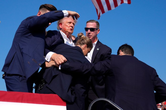 Donald Trump, el virtual candidato presidencial republicano, es custodiado por agentes del Servicio Secreto de Estados Unidos durante un aparente intento de asesinato en un acto de campaña, el sábado 13 de julio de 2024, en Butler, Pensilvania. (AP Foto/Evan Vucci)